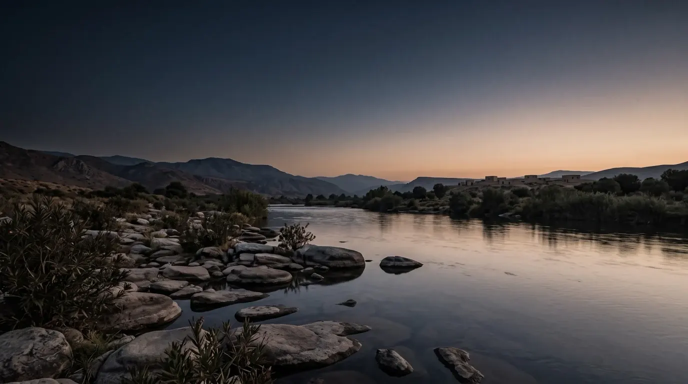 A quiet riverbank with flat stones by the water.