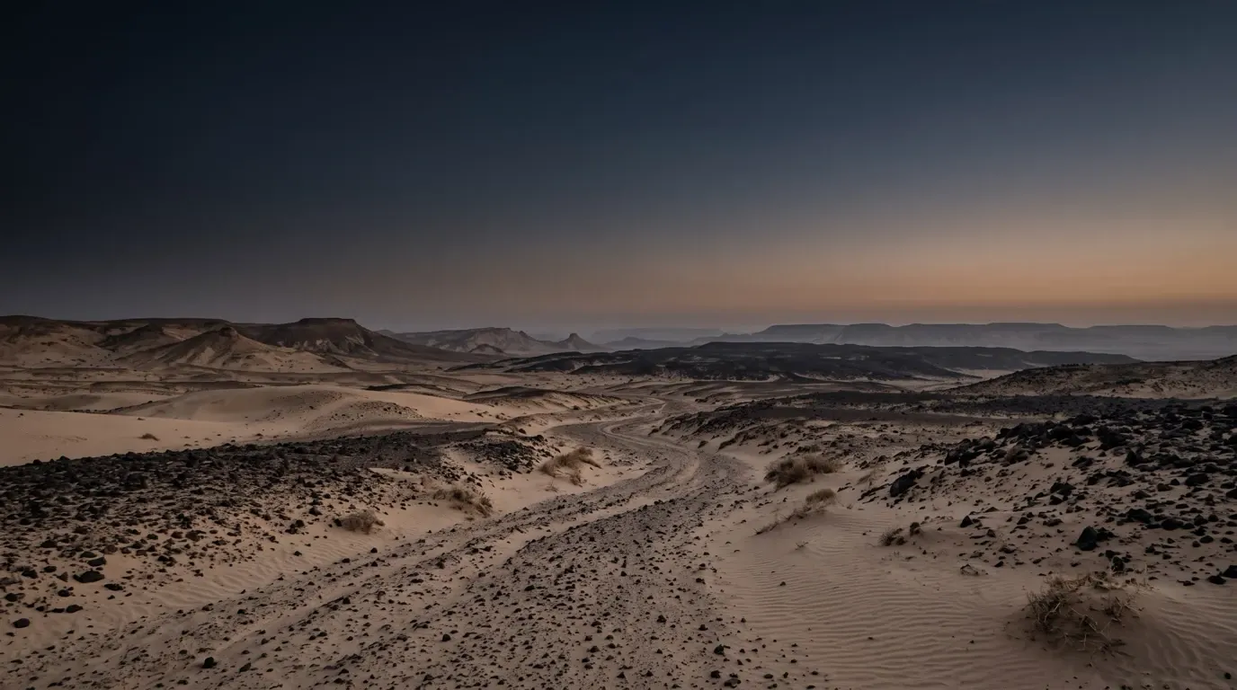 Dunes and fields of black basalt stones in a desert.