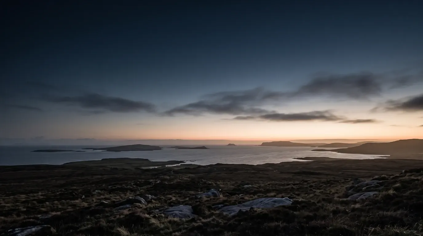A wide prospect of scattered coastlands and islands under travelling clouds.