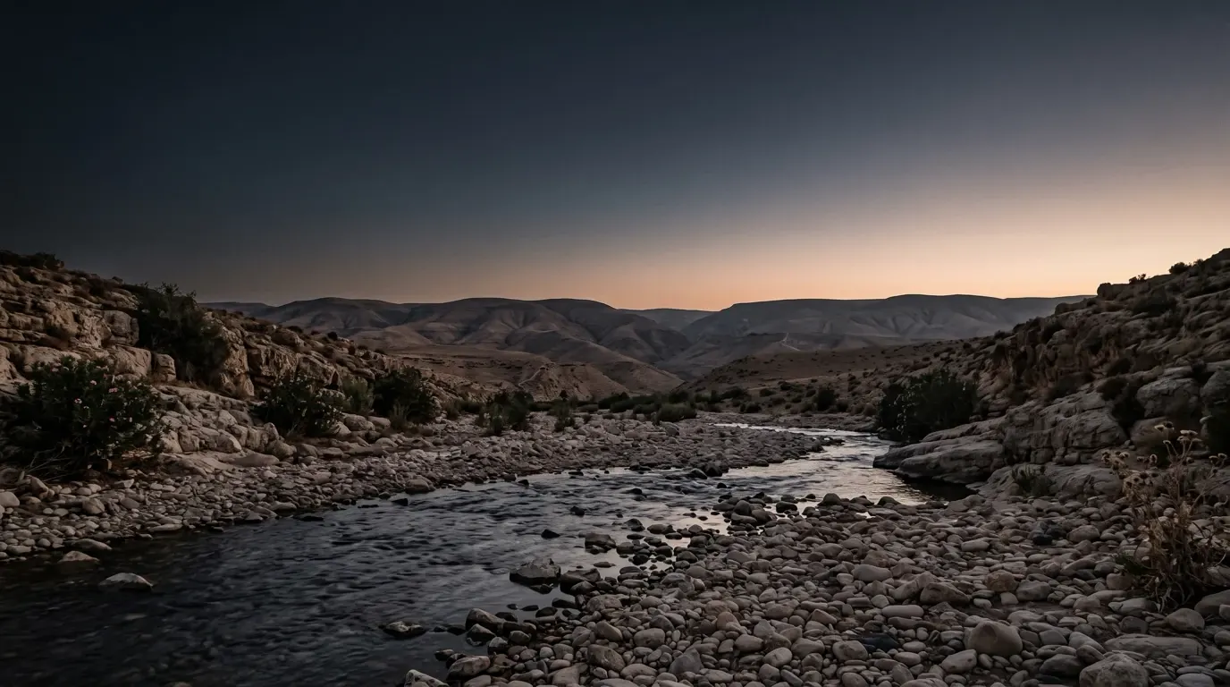 A stony ford where a river braids over rocks between steep banks.
