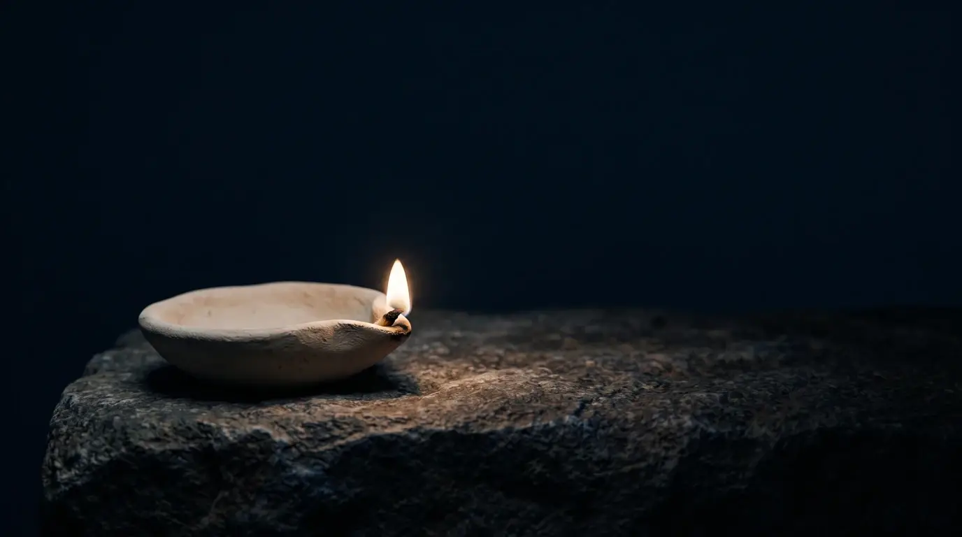 A single lamp burning in deep darkness, its light reaching further than the dark closes in.
