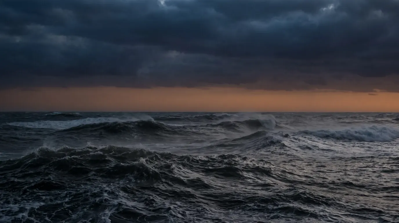 A wide sea whipped into heavy waves under a low storm sky, no coast in sight.