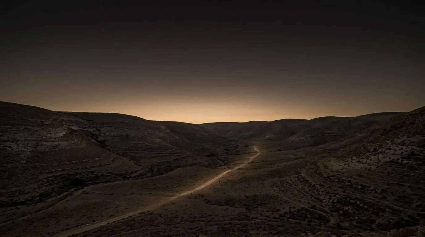 A broad flat open plain of dry grass lying level between two ranges of dry hills.