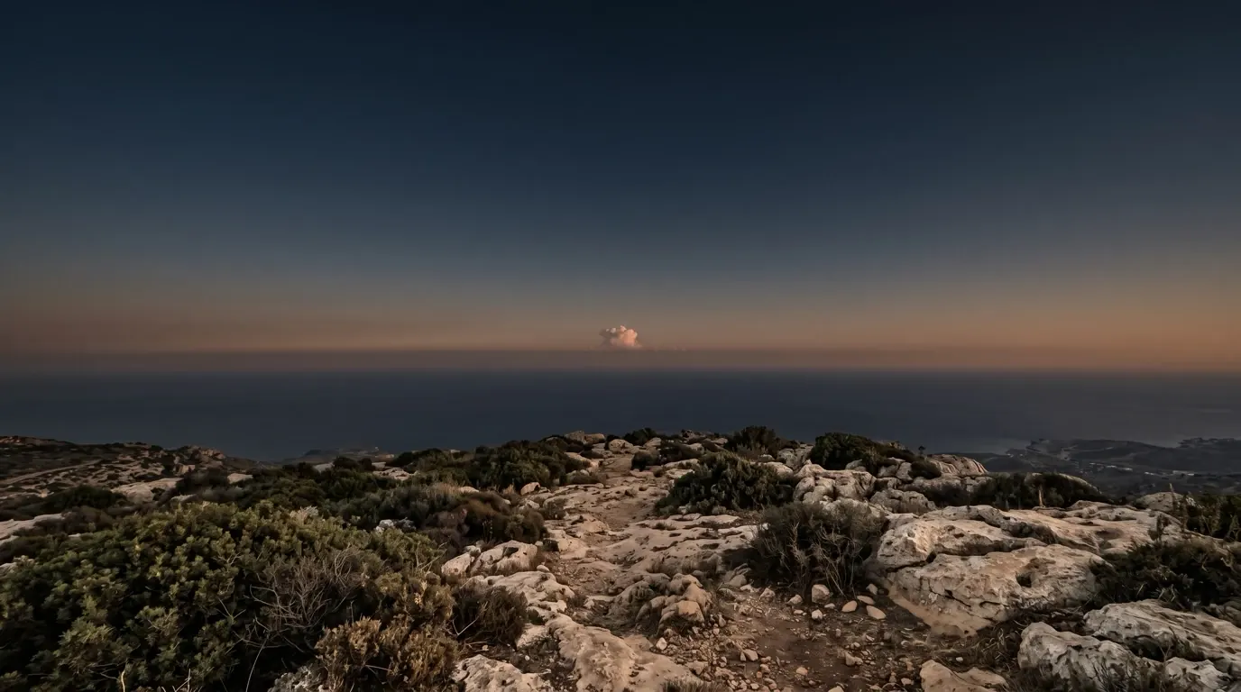 A small cloud rising from the sea on the far horizon.