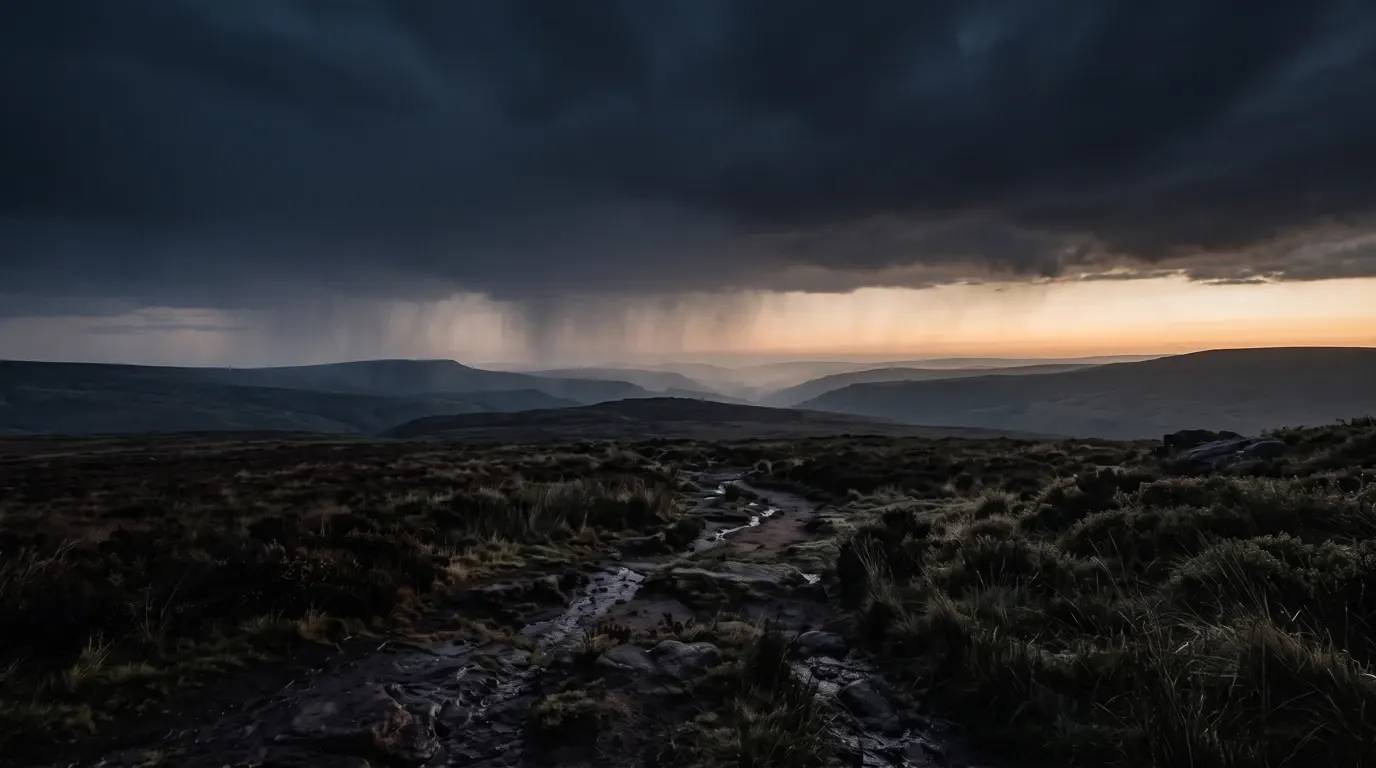 A wide land under heavy weather at first light, the horizon just beginning to open.